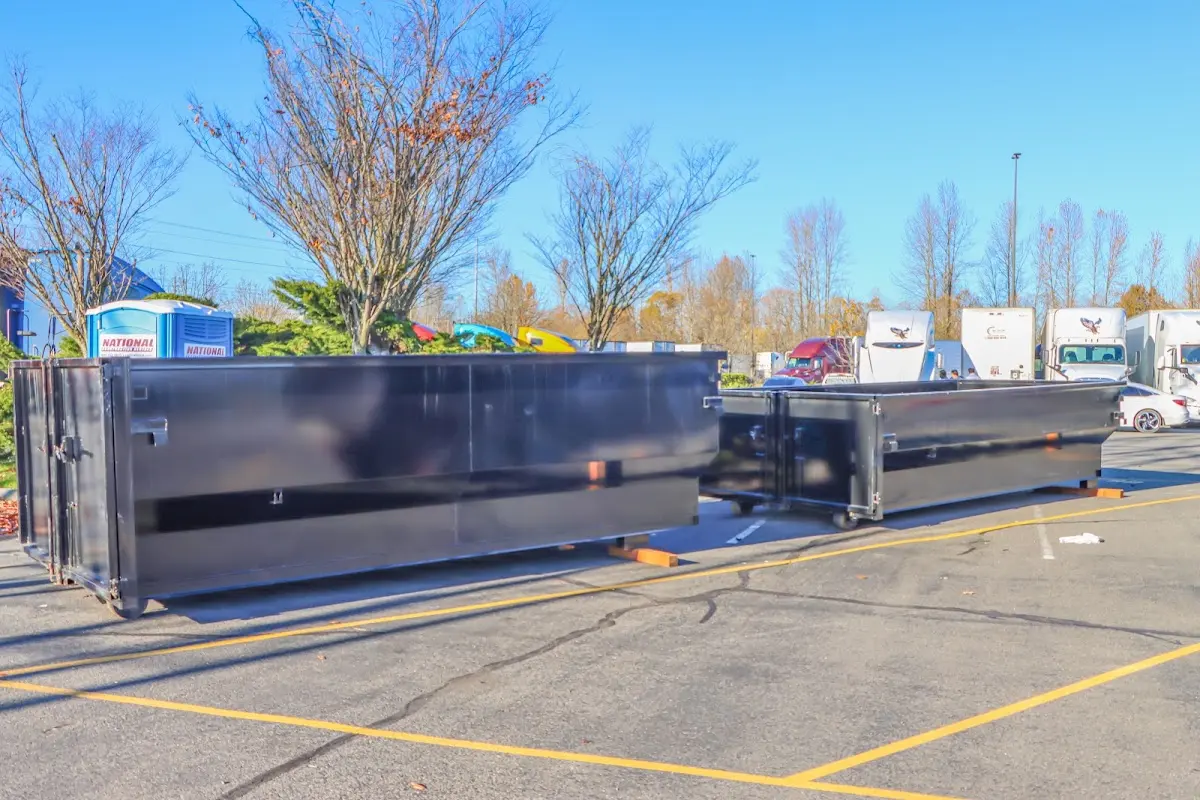 Professional dumpster rental service with roll-off container on residential driveway in Blackman